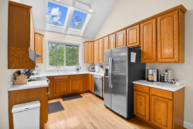 1117 Cliffs Edge Rd, East Bernstadt, KY 40729 - kitchen with appliances with stainless steel finishes, a skylight, light wood-style floors, brown cabinetry, and lofted ceiling