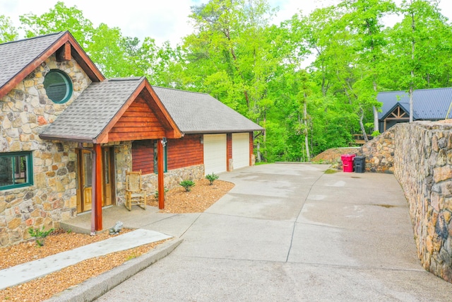 1117 Cliffs Edge Rd, East Bernstadt, KY 40729 - view of side of home with stone siding, a shingled roof, and a garage
