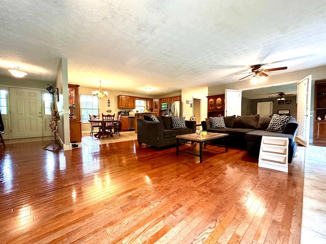 315 Sukey Hollow Rd, Williamsburg, KY 40769 - living area featuring light wood-style flooring, a textured ceiling, ceiling fan, and a chandelier