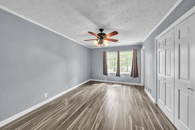 324 Circle Dr, Morehead, KY 40351 - unfurnished bedroom featuring dark wood-type flooring, baseboards, a closet, a textured ceiling, and crown molding