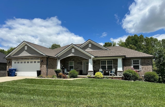 craftsman inspired home featuring covered porch, a front lawn, a garage, concrete driveway, and stone siding
