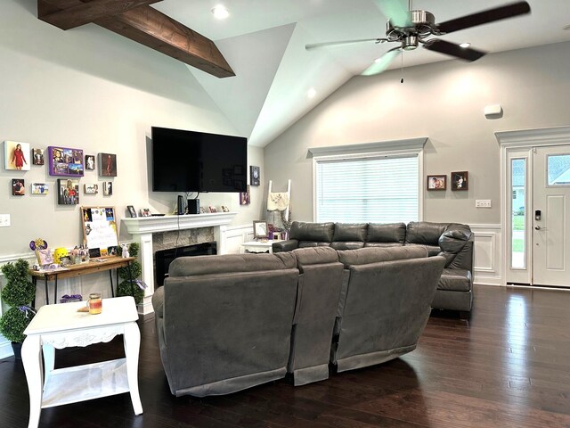 living area featuring a ceiling fan, a wainscoted wall, lofted ceiling, hardwood / wood-style floors, and a fireplace