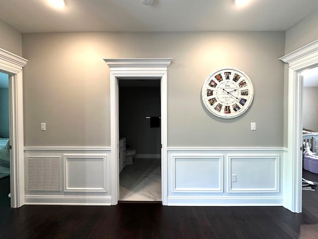 hallway with a wainscoted wall and a decorative wall