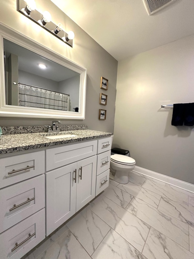 bathroom with marble look tiles, vanity, baseboards, and toilet