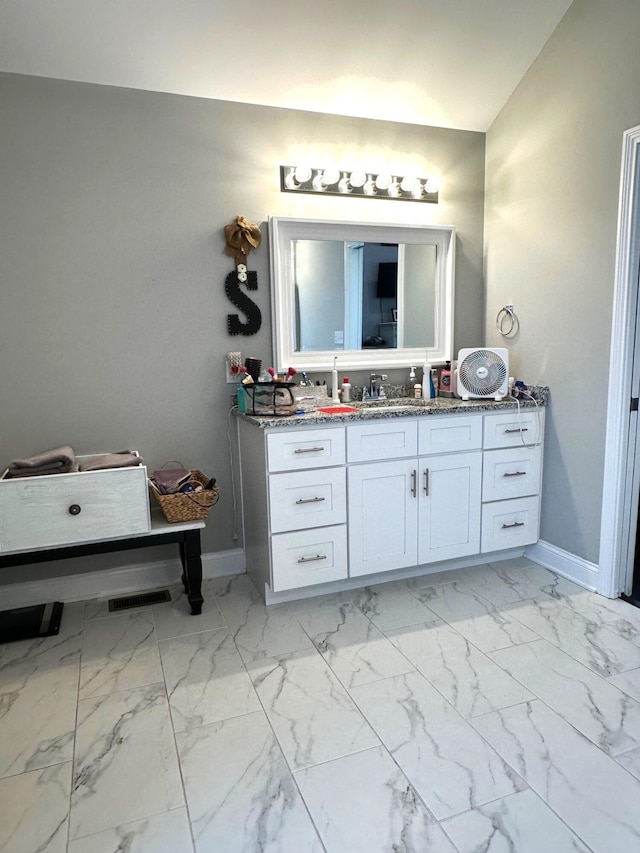 bathroom featuring baseboards, vanity, and marble look tile flooring