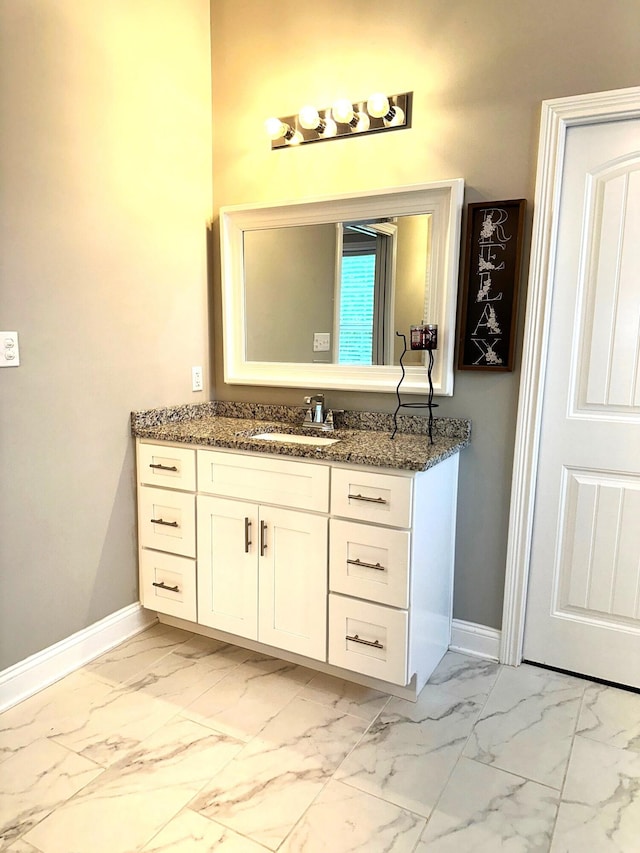 bathroom featuring marble finish flooring, baseboards, and vanity