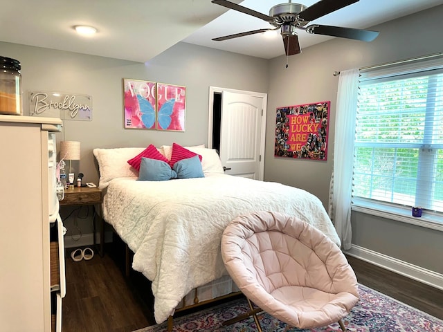 bedroom with multiple windows, wood finished floors, baseboards, and ceiling fan