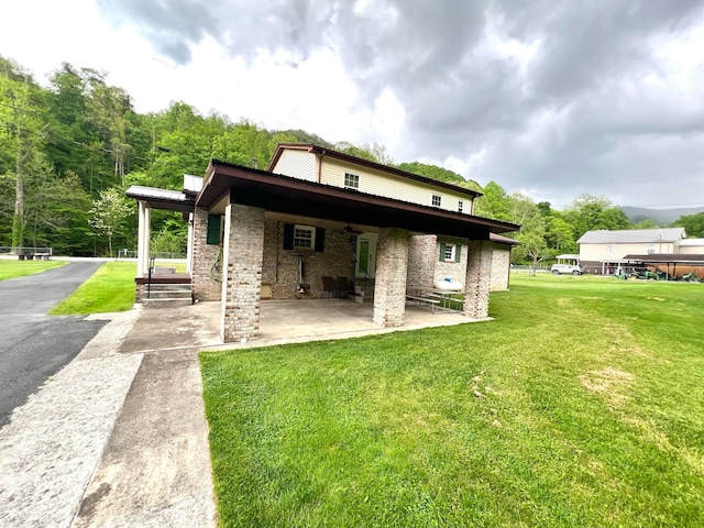 4758 Cloverlick Rd, Cumberland, KY 40823 - back of house with ceiling fan, a yard, a patio, and brick siding