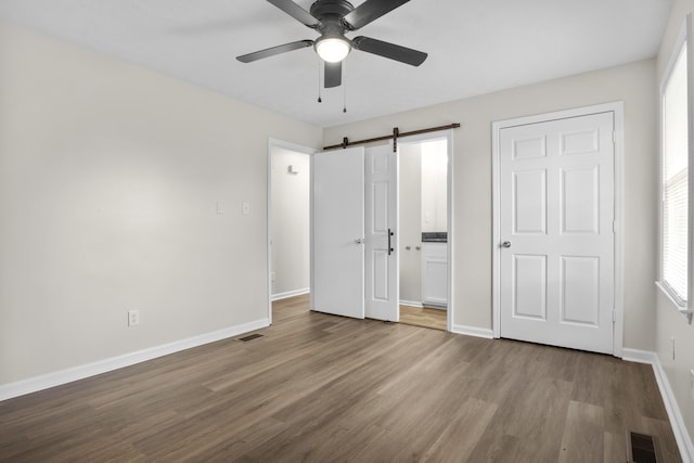 340 Wise Dr, Wilmore, KY 40390 - unfurnished bedroom with a barn door, wood finished floors, baseboards, and ceiling fan
