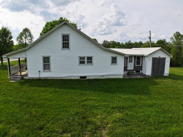 rear view of property with a lawn and entry steps