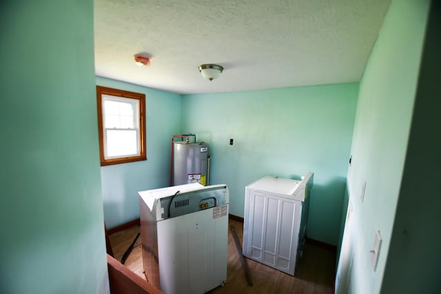 washroom with electric water heater, baseboards, wood finished floors, and a textured ceiling