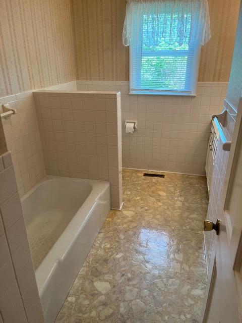 1819 N 27th Hwy, Cynthiana, KY 41031 - bathroom featuring wallpapered walls, a garden tub, tile walls, and wainscoting