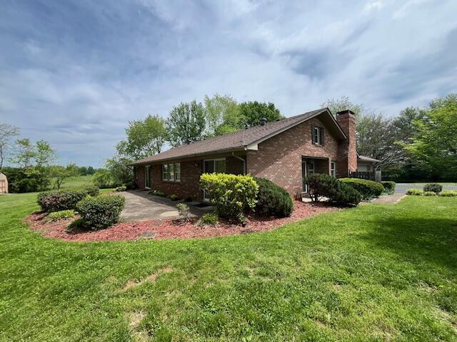 1819 N 27th Hwy, Cynthiana, KY 41031 - view of home's exterior featuring a chimney, brick siding, and a lawn