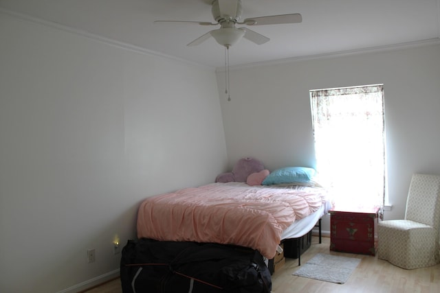bedroom with light wood-style floors, crown molding, and ceiling fan