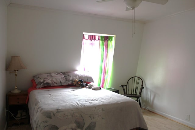 bedroom with light wood-type flooring, crown molding, ceiling fan, and baseboards