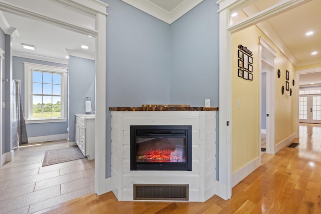 324 Hays Mays Rd, Perryville, KY 40468 - detailed view of ornamental molding, a glass covered fireplace, wood finished floors, baseboards, and recessed lighting