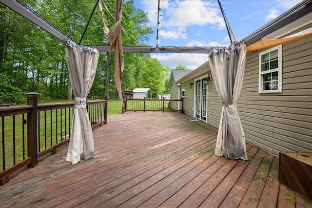 wooden terrace featuring a lawn