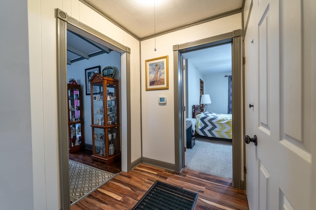corridor featuring dark wood-style flooring and baseboards