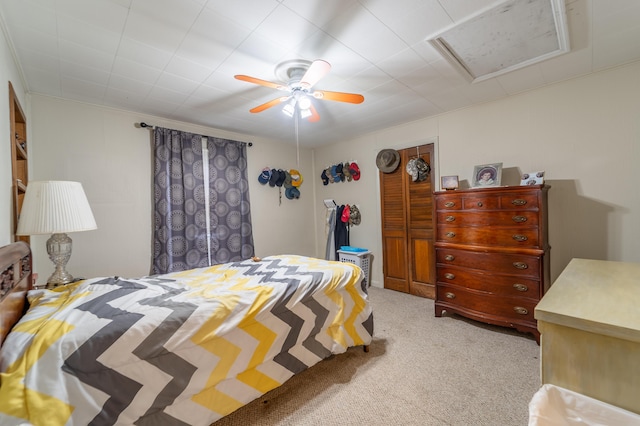 bedroom with light carpet, attic access, and a ceiling fan