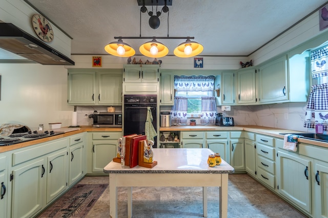 kitchen with stainless steel microwave, green cabinets, range hood, backsplash, and light countertops