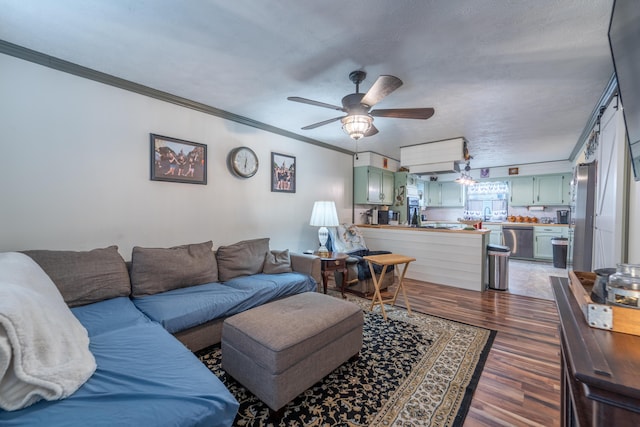 living room with ornamental molding, dark wood-style flooring, and ceiling fan