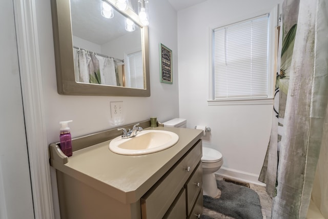 bathroom featuring toilet, vanity, and curtained shower
