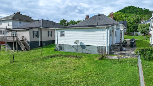 back of property with stairs, a lawn, and a wooden deck