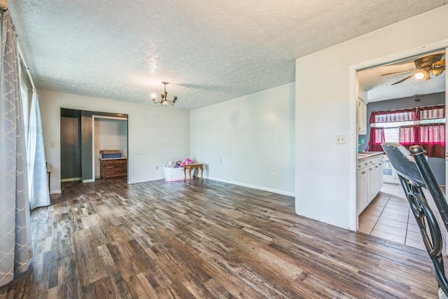 3202 W Cumberland Ave, Middlesboro, KY 40965 - unfurnished dining area with wood finished floors, a chandelier, a textured ceiling, and ceiling fan