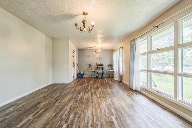 3202 W Cumberland Ave, Middlesboro, KY 40965 - unfurnished dining area with a chandelier, wood finished floors, a textured ceiling, baseboards, and plenty of natural light