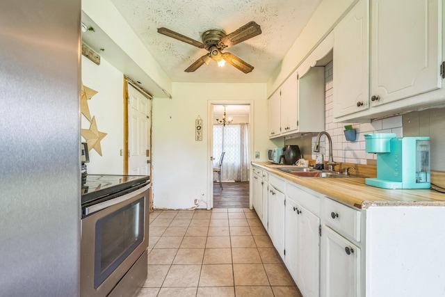 3202 W Cumberland Ave, Middlesboro, KY 40965 - kitchen with stainless steel electric range oven, a sink, white cabinetry, and a textured ceiling