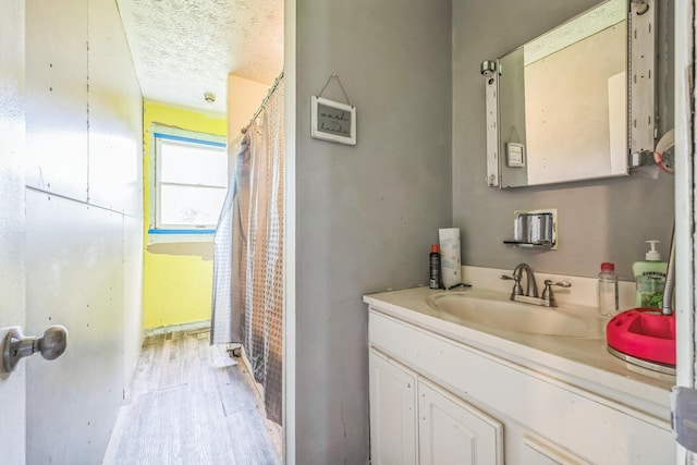 3202 W Cumberland Ave, Middlesboro, KY 40965 - full bath featuring vanity, wood finished floors, and a textured ceiling