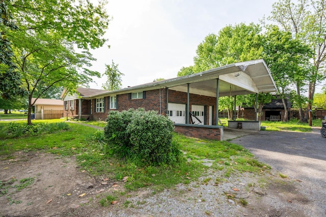 3202 W Cumberland Ave, Middlesboro, KY 40965 - view of front of house with brick siding, driveway, and a carport