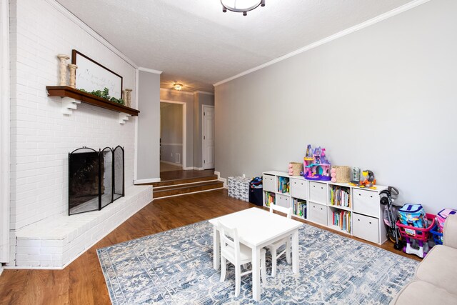 3476 Grasmere Dr, Lexington, KY 40503 - recreation room with wood finished floors, ornamental molding, a brick fireplace, a textured ceiling, and baseboards