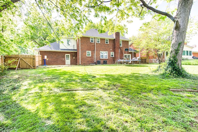 3476 Grasmere Dr, Lexington, KY 40503 - rear view of property with a chimney, brick siding, a trampoline, a gate, and a shingled roof
