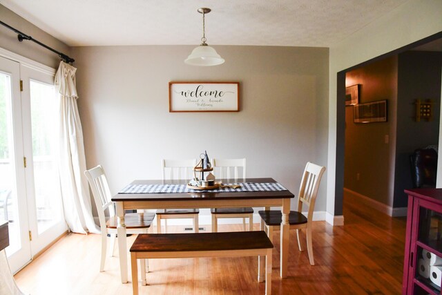 dining room featuring light wood finished floors and baseboards