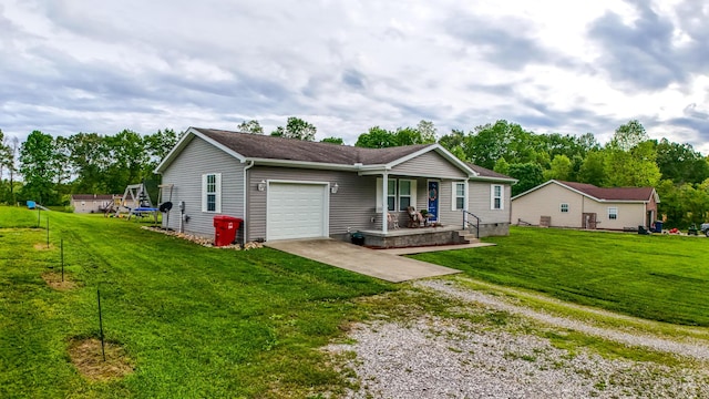 ranch-style home featuring driveway, a garage, covered porch, and a front yard