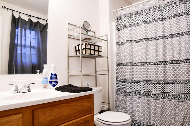 full bathroom featuring toilet, vanity, and a shower with shower curtain