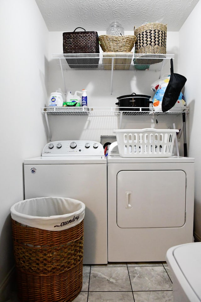 clothes washing area featuring washing machine and clothes dryer and light tile patterned floors