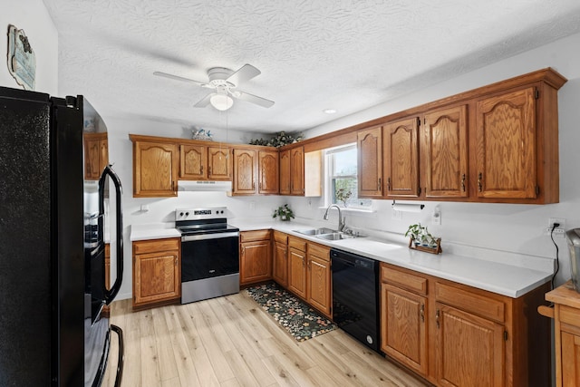 129 Bay Hill Dr, Winchester, KY 40391 - kitchen featuring black appliances, under cabinet range hood, a sink, brown cabinetry, and light wood finished floors