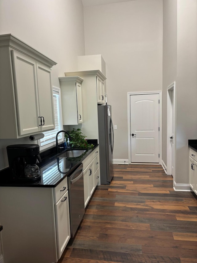 875 Ridgeview Dr, Frankfort, KY 40601 - kitchen with a high ceiling, stainless steel appliances, a sink, dark countertops, and dark wood-style flooring