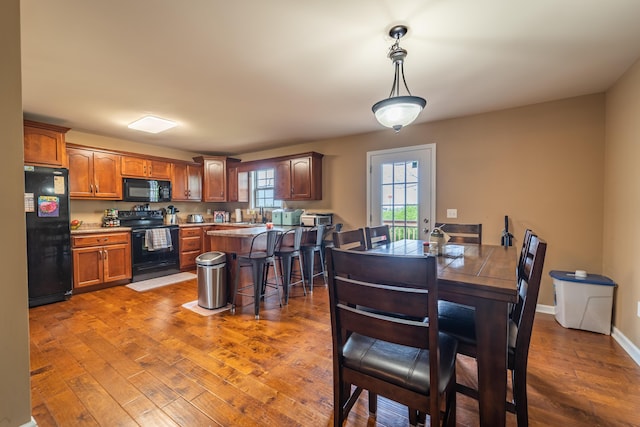 dining space featuring wood finished floors and baseboards