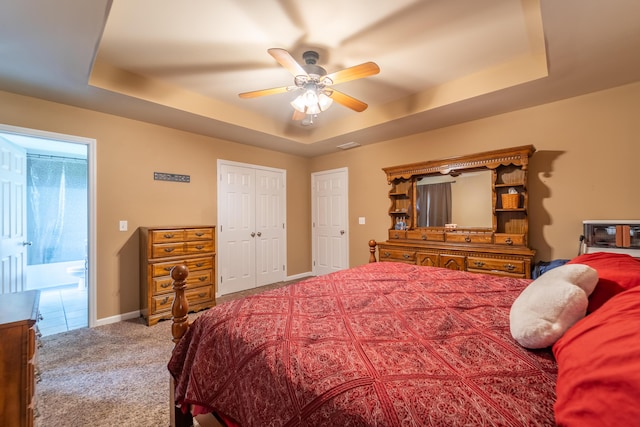bedroom featuring a tray ceiling, carpet floors, ceiling fan, and baseboards