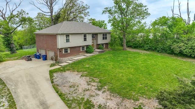 back of property with brick siding, concrete driveway, an attached garage, and a lawn