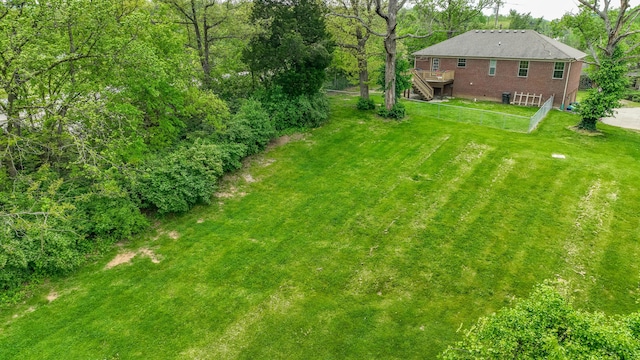 view of green lawn featuring a deck