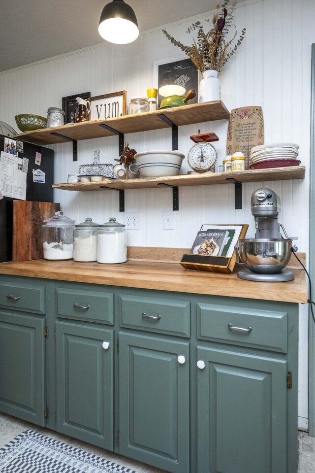 kitchen featuring stainless steel appliances, a sink, open shelves, butcher block counters, and glass insert cabinets