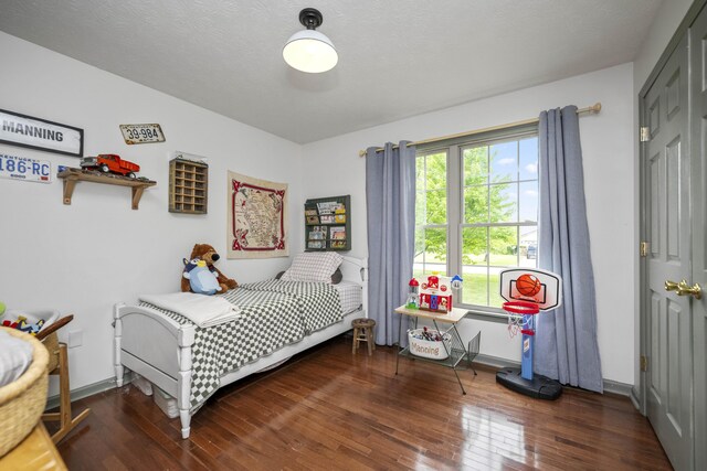 bedroom with dark wood-style floors and a textured ceiling