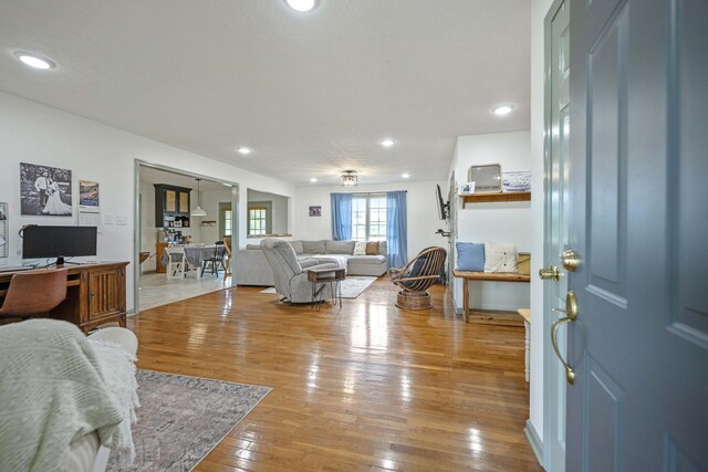 living area with wood finished floors, baseboards, and recessed lighting