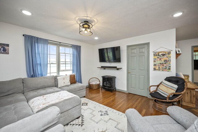 living room featuring wood finished floors, recessed lighting, a textured ceiling, and baseboards