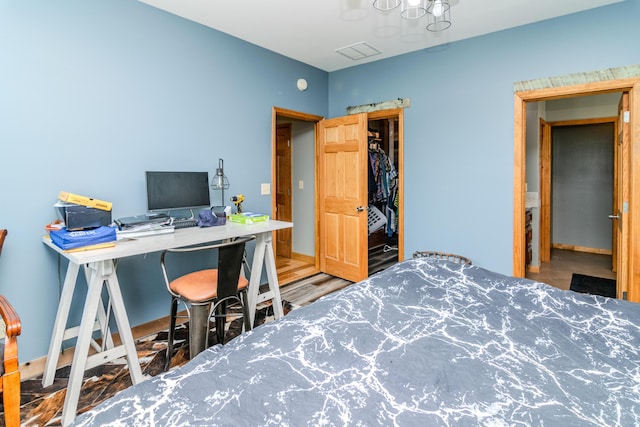 bedroom featuring an office area and a chandelier