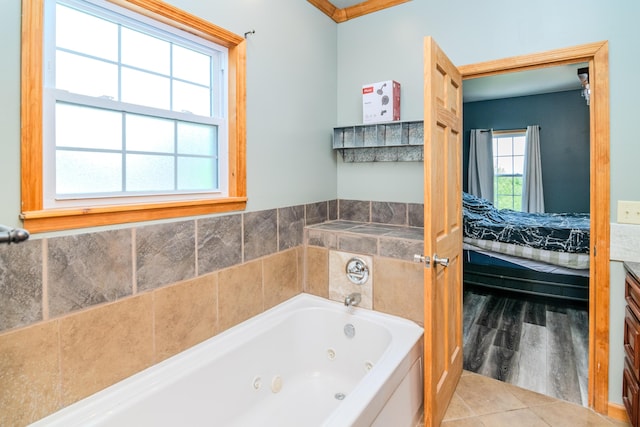 bathroom with a tub with jets, wood finished floors, ensuite bath, and vanity